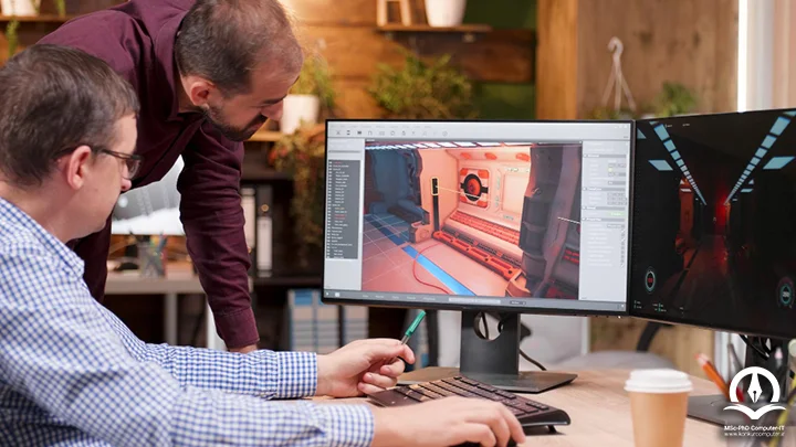 در این تصویر دو شخص بر روی تصویری که روی صفحه مانیتور کامپیوتر نمایش داده شده است، کار می کنند