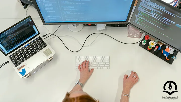 در این تصویر، خانمی در مقابل مانیتوری که کدهای کامپیتوری روی آن به نمایش درآمده اند، قرار دارد و در حال کدنویسی می باشد
